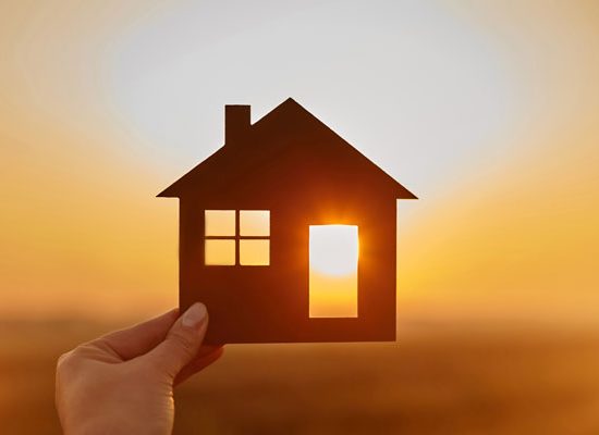Woman hand holds wooden house against the sun. Solar energy. Children dreams. International day of families. Home protection insurance concept. Planning to buy property. A symbol for ecology. "nAffordable housing. Real estate agent offer house. Choose what's the best.